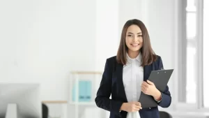  woman lawyer in a business suit confidently holds a clipboard, ready for her next case or meeting.